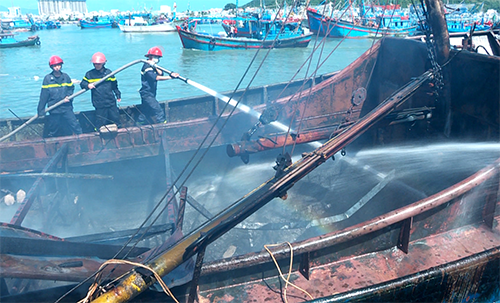 Cảnh sát chữa cháy phun nước dập lửa trong tàu cá cháy trong cảng ở Nha Trang. Ảnh: Xuân Ngọc