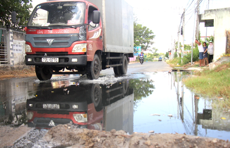 Nước thải chảy tràn trên con đường liên xã. Ảnh: Nguyễn Khoa.