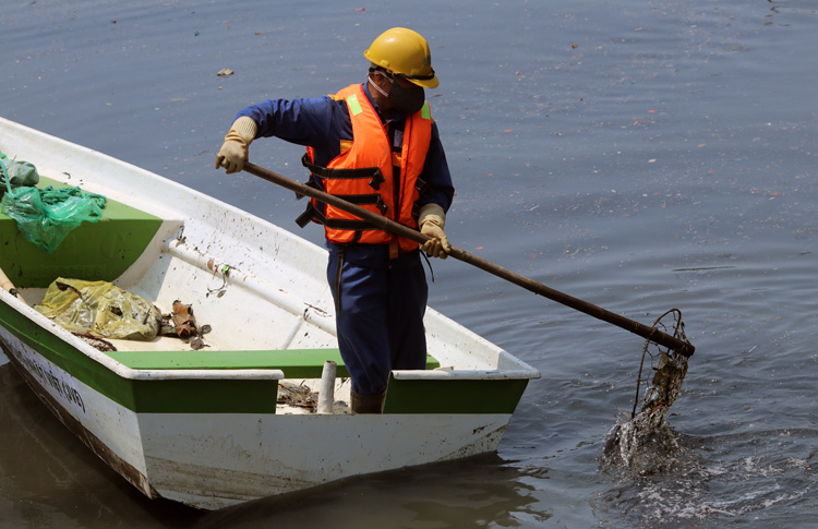 Công nhân công ty thoát nước Hà Nội dọn rác trên sông Tô Lịch. Ảnh: Võ Hải.