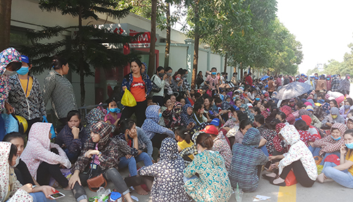 Hàng nghìn công nhân ở Khu công nghiệp Hoàng Long hôm nay nghỉ việc, tập trung quanh khuôn viên nhà máy đòi tăng lương. Ảnh: Lam Sơn.
