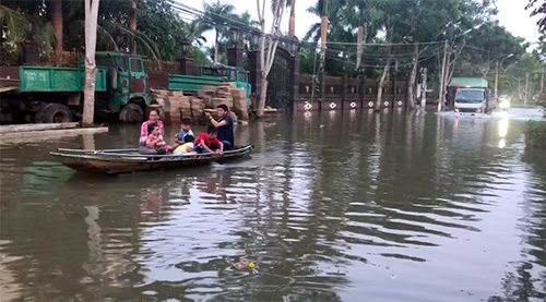 Ngập sâu, người dân lấy xuồng bơi trên lộ ở một khu dân cư mới tại quận trung tâm Ninh Kiều. Ảnh: Hồng Thắm 
