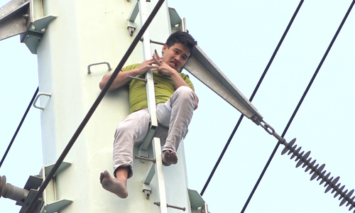 Nam thanh niên cố thủ nhiều giờ trên cột điện cao thế